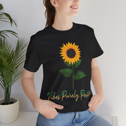 Sunflower illustration with 'Vibes Purely Positive' phrase - a vibrant sunflower with yellow petals and dark brown center, green leaves on a stem, conveying a positive message printed in t-shirts of different colors like "Army Athletic Heather Berry Black Heather Navy Heather Team Purple Navy White Ash Heather Aqua"