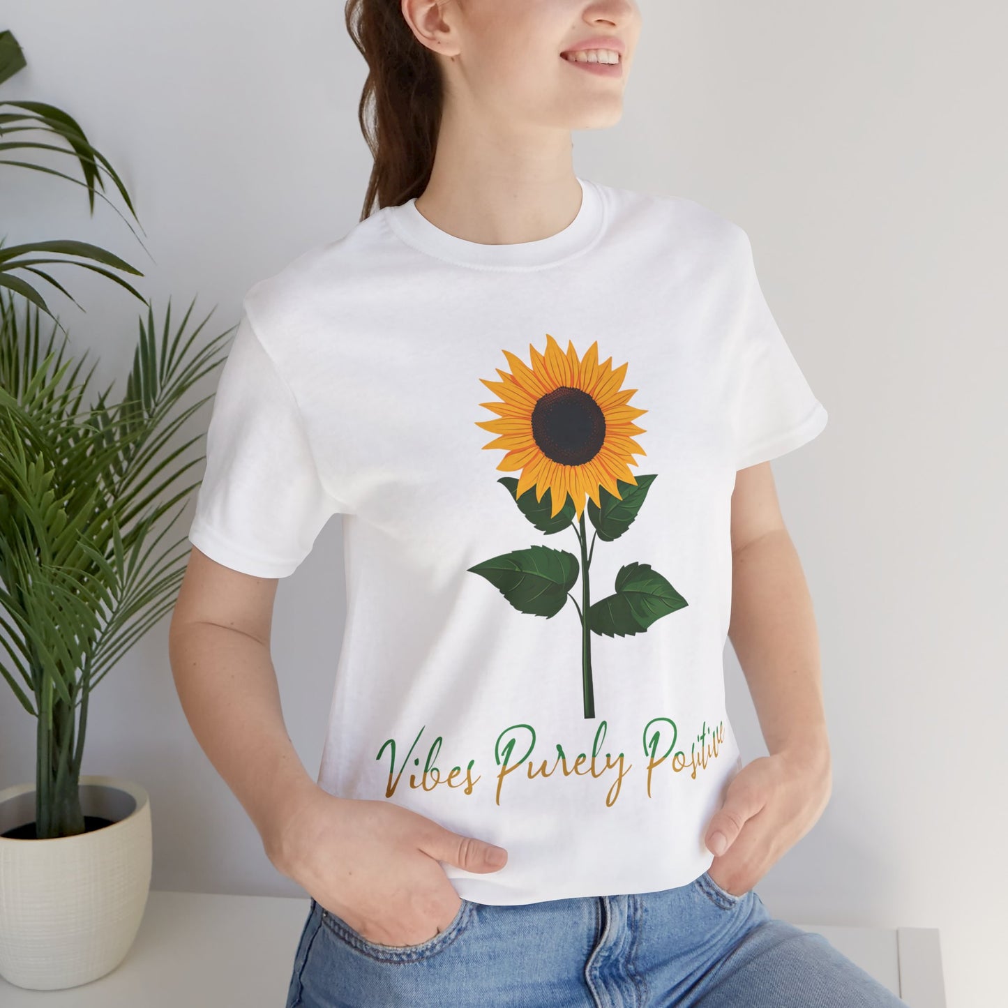 Sunflower illustration with 'Vibes Purely Positive' phrase - a vibrant sunflower with yellow petals and dark brown center, green leaves on a stem, conveying a positive message printed in t-shirts of different colors like "Army Athletic Heather Berry Black Heather Navy Heather Team Purple Navy White Ash Heather Aqua"