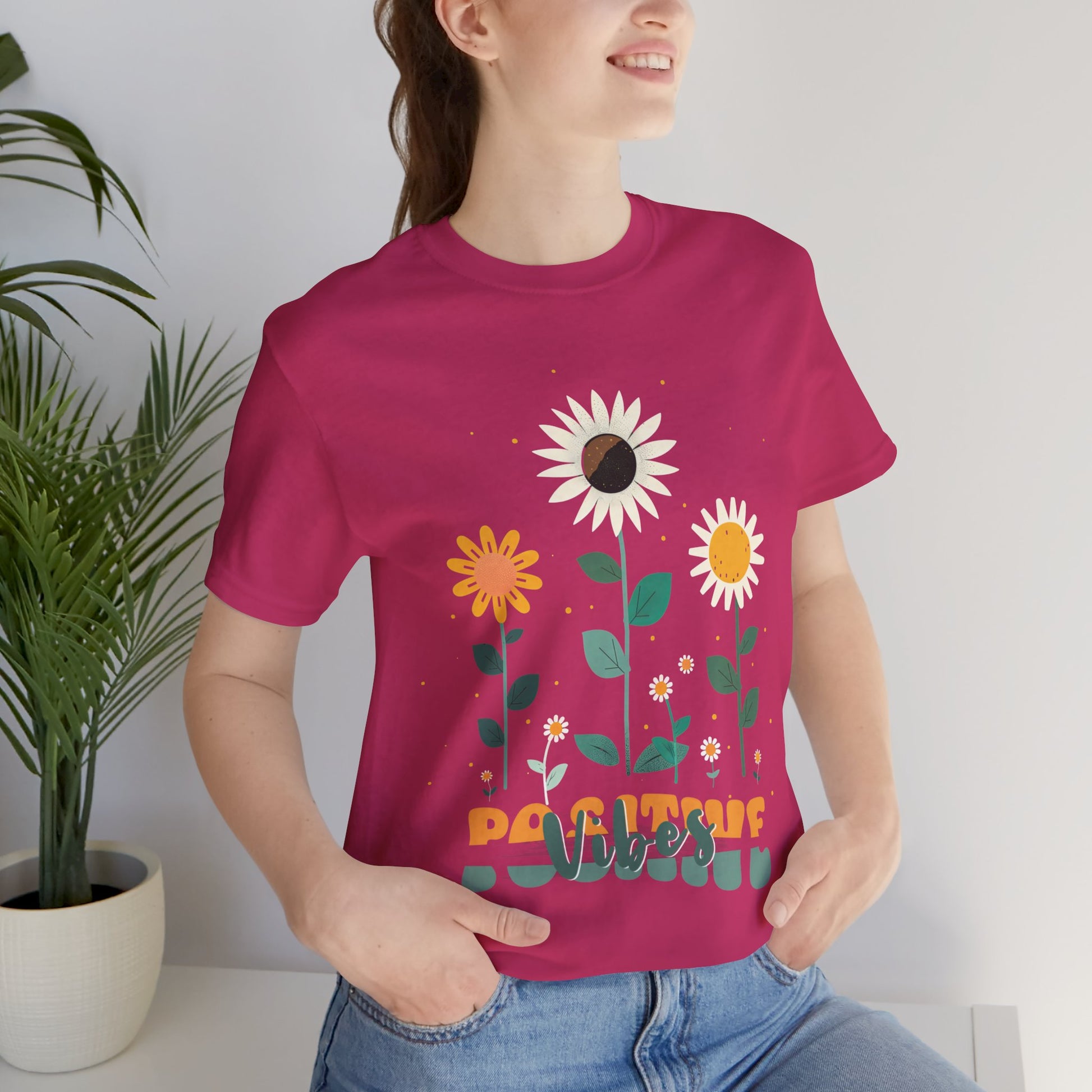 Colorful floral illustration with 'Positive Vibes' - featuring a trio of vibrant flowers, including a sunflower-like bloom with white petals, an orange flower with simple petals, and a yellow flower with round petals, all set against a light backdrop adorned with whimsical dots and the uplifting phrase 'Positive Vibes' in playful orange font, Aqua, Athletic Heather, Berry, Black, Dark Grey, Dark, Grey, Heather, Heather Kelly, Heather Red, Heather Team, Purple, Navy, Pink, Ash, Heather, Aqua, Charity Pink