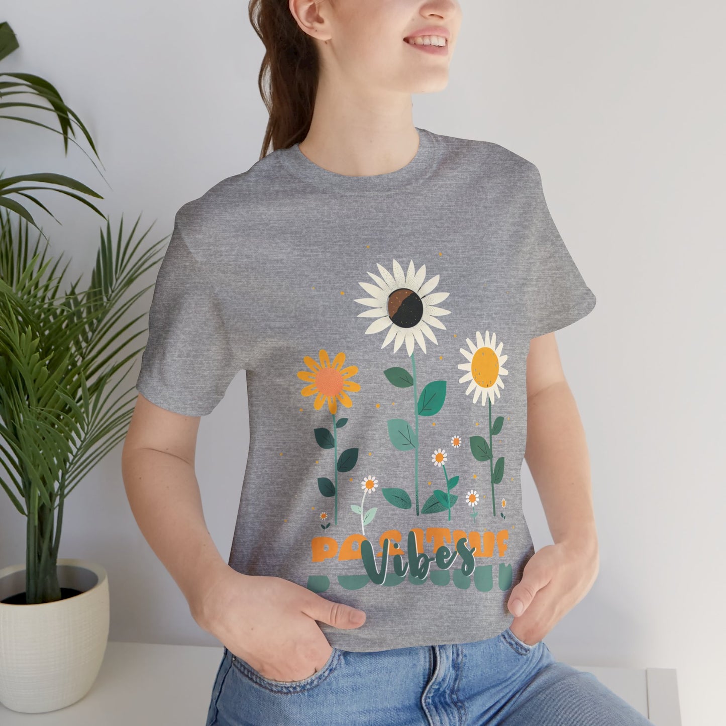 Colorful floral illustration with 'Positive Vibes' - featuring a trio of vibrant flowers, including a sunflower-like bloom with white petals, an orange flower with simple petals, and a yellow flower with round petals, all set against a light backdrop adorned with whimsical dots and the uplifting phrase 'Positive Vibes' in playful orange font, Aqua, Athletic Heather, Berry, Black, Dark Grey, Dark, Grey, Heather, Heather Kelly, Heather Red, Heather Team, Purple, Navy, Pink, Ash, Heather, Aqua, Charity Pink