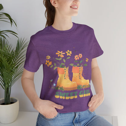 “Chic boho-style boots adorned with floral accents and ‘Sweet Girl’ text, featured on Bella Canvas 3001 t-shirts in a variety of hues Athletic Heather Berry Black Dark Grey Heather Heather Team Purple Navy White Heather Aqua Charity Pink.”