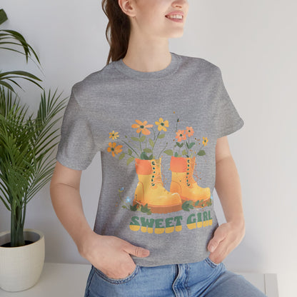 “Chic boho-style boots adorned with floral accents and ‘Sweet Girl’ text, featured on Bella Canvas 3001 t-shirts in a variety of hues Athletic Heather Berry Black Dark Grey Heather Heather Team Purple Navy White Heather Aqua Charity Pink.”