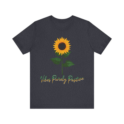 Sunflower illustration with 'Vibes Purely Positive' phrase - a vibrant sunflower with yellow petals and dark brown center, green leaves on a stem, conveying a positive message printed in t-shirts of different colors like "Army Athletic Heather Berry Black Heather Navy Heather Team Purple Navy White Ash Heather Aqua"