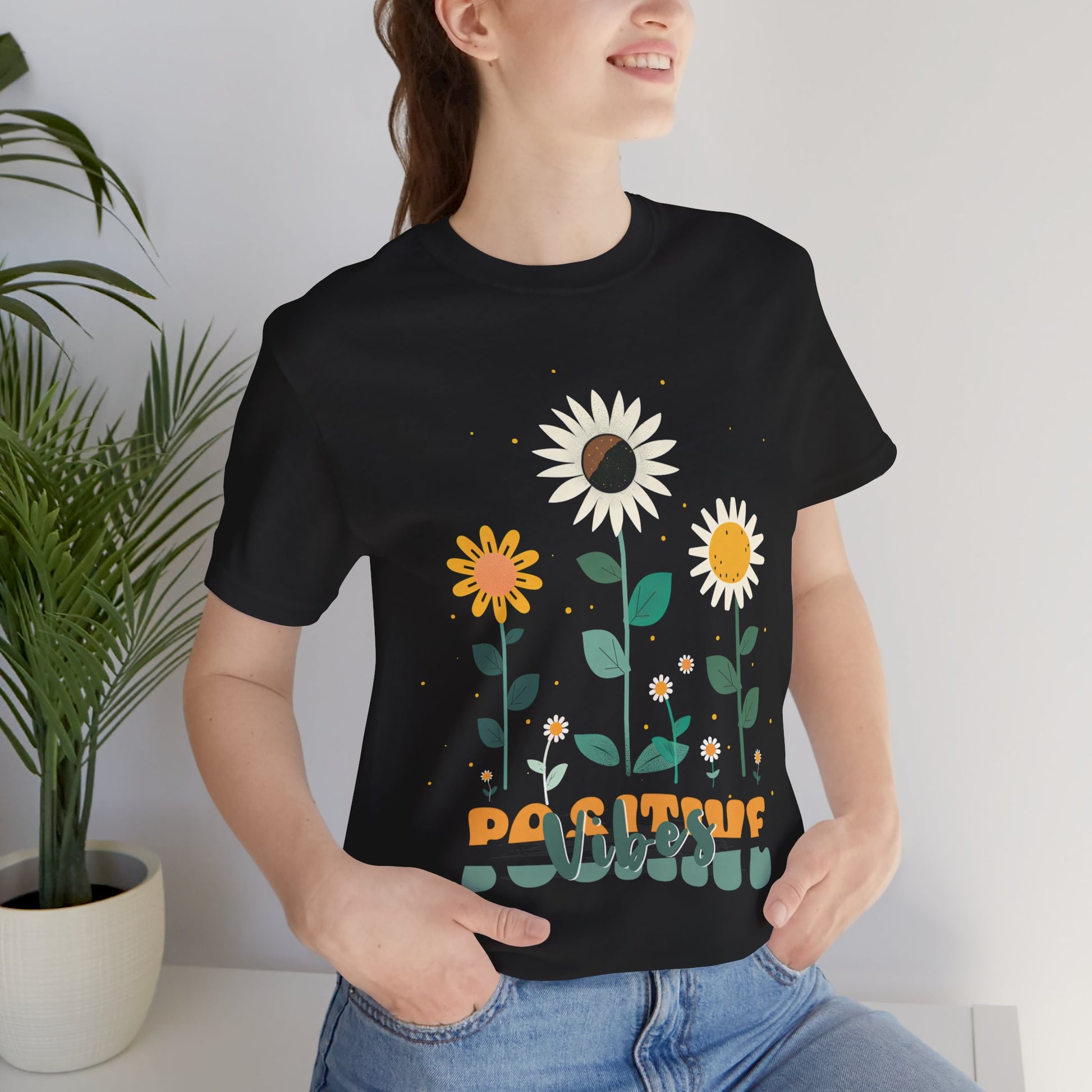 Colorful floral illustration with 'Positive Vibes' - featuring a trio of vibrant flowers, including a sunflower-like bloom with white petals, an orange flower with simple petals, and a yellow flower with round petals, all set against a light backdrop adorned with whimsical dots and the uplifting phrase 'Positive Vibes' in playful orange font, Aqua, Athletic Heather, Berry, Black, Dark Grey, Dark, Grey, Heather, Heather Kelly, Heather Red, Heather Team, Purple, Navy, Pink, Ash, Heather, Aqua, Charity Pink