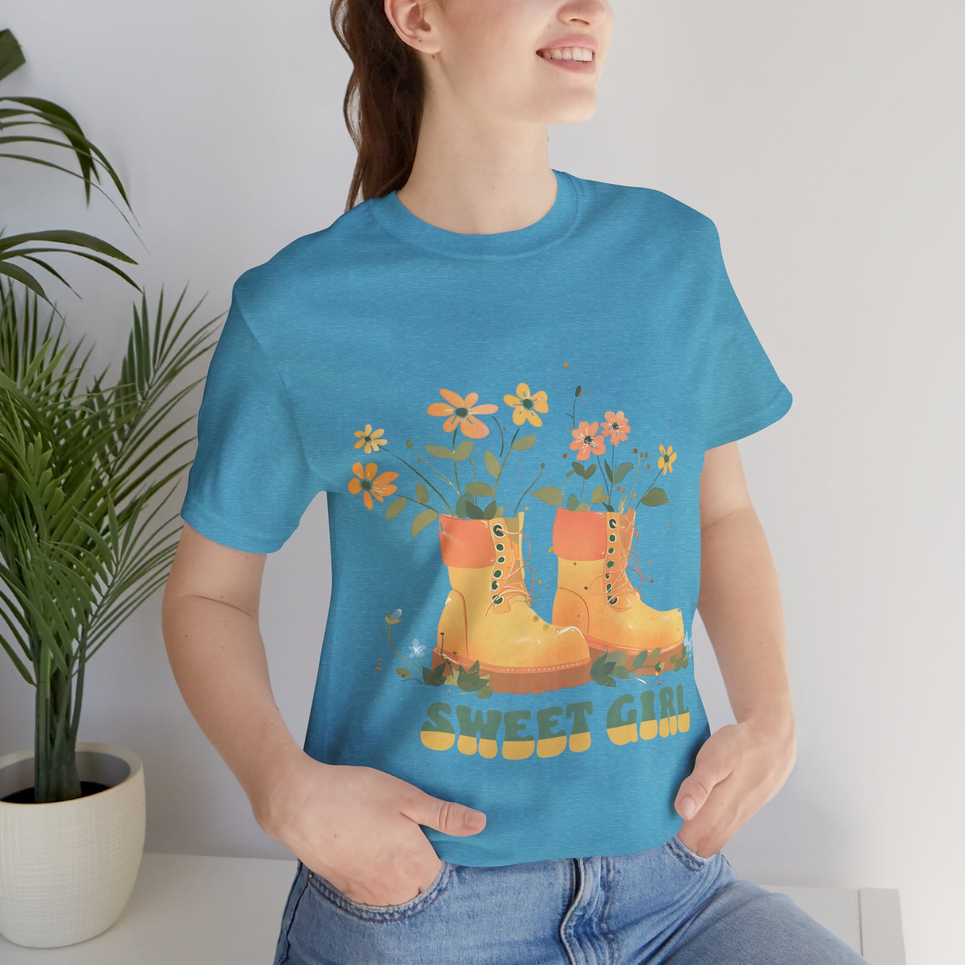 “Chic boho-style boots adorned with floral accents and ‘Sweet Girl’ text, featured on Bella Canvas 3001 t-shirts in a variety of hues Athletic Heather Berry Black Dark Grey Heather Heather Team Purple Navy White Heather Aqua Charity Pink.”