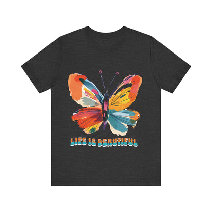 Colorful cartoon-style butterfly with vibrant wings and the text 'Life is Beautiful' designed for t-shirts in colors including Aqua, Athletic Heather, Berry, Black, Dark Grey Heather, Heather Red, Heather Team Purple, Heather True Royal, White, and Charity Pink