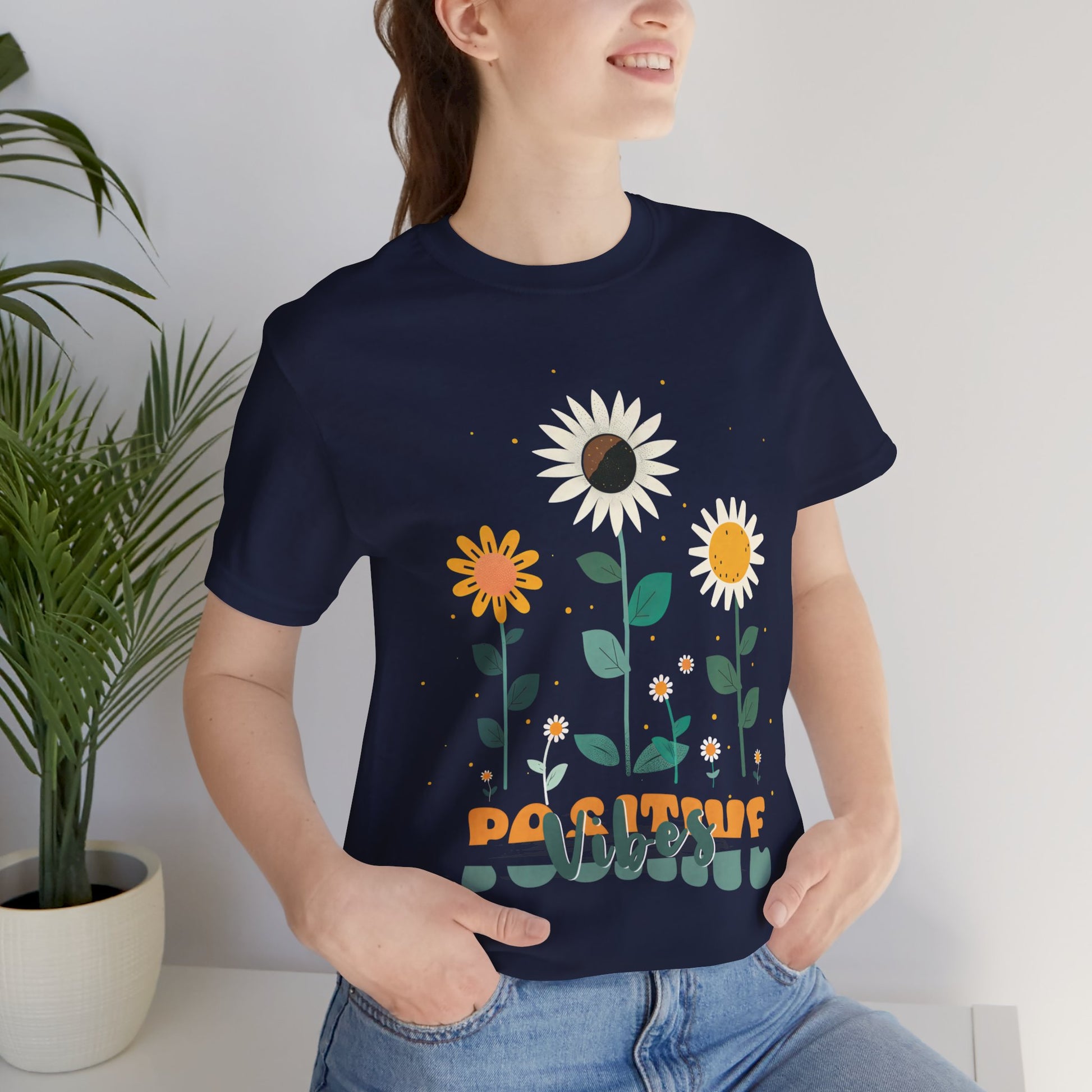 Colorful floral illustration with 'Positive Vibes' - featuring a trio of vibrant flowers, including a sunflower-like bloom with white petals, an orange flower with simple petals, and a yellow flower with round petals, all set against a light backdrop adorned with whimsical dots and the uplifting phrase 'Positive Vibes' in playful orange font, Aqua, Athletic Heather, Berry, Black, Dark Grey, Dark, Grey, Heather, Heather Kelly, Heather Red, Heather Team, Purple, Navy, Pink, Ash, Heather, Aqua, Charity Pink