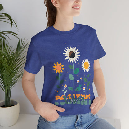 Colorful floral illustration with 'Positive Vibes' - featuring a trio of vibrant flowers, including a sunflower-like bloom with white petals, an orange flower with simple petals, and a yellow flower with round petals, all set against a light backdrop adorned with whimsical dots and the uplifting phrase 'Positive Vibes' in playful orange font, Aqua, Athletic Heather, Berry, Black, Dark Grey, Dark, Grey, Heather, Heather Kelly, Heather Red, Heather Team, Purple, Navy, Pink, Ash, Heather, Aqua, Charity Pink