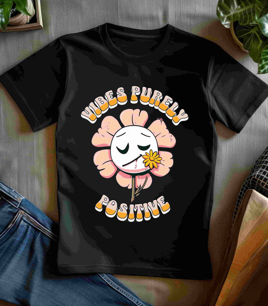 Cute pink flower with a smiling face and a yellow flower in its mouth, accompanied by the text "Vibes Purely Positive." This cheerful design is perfect for t-shirts available in colors Aqua, Berry, Black, Dark Gray, Heather Kelly, Heather Team Purple, Heather True Royal, Navy, White, and Charity Pink.