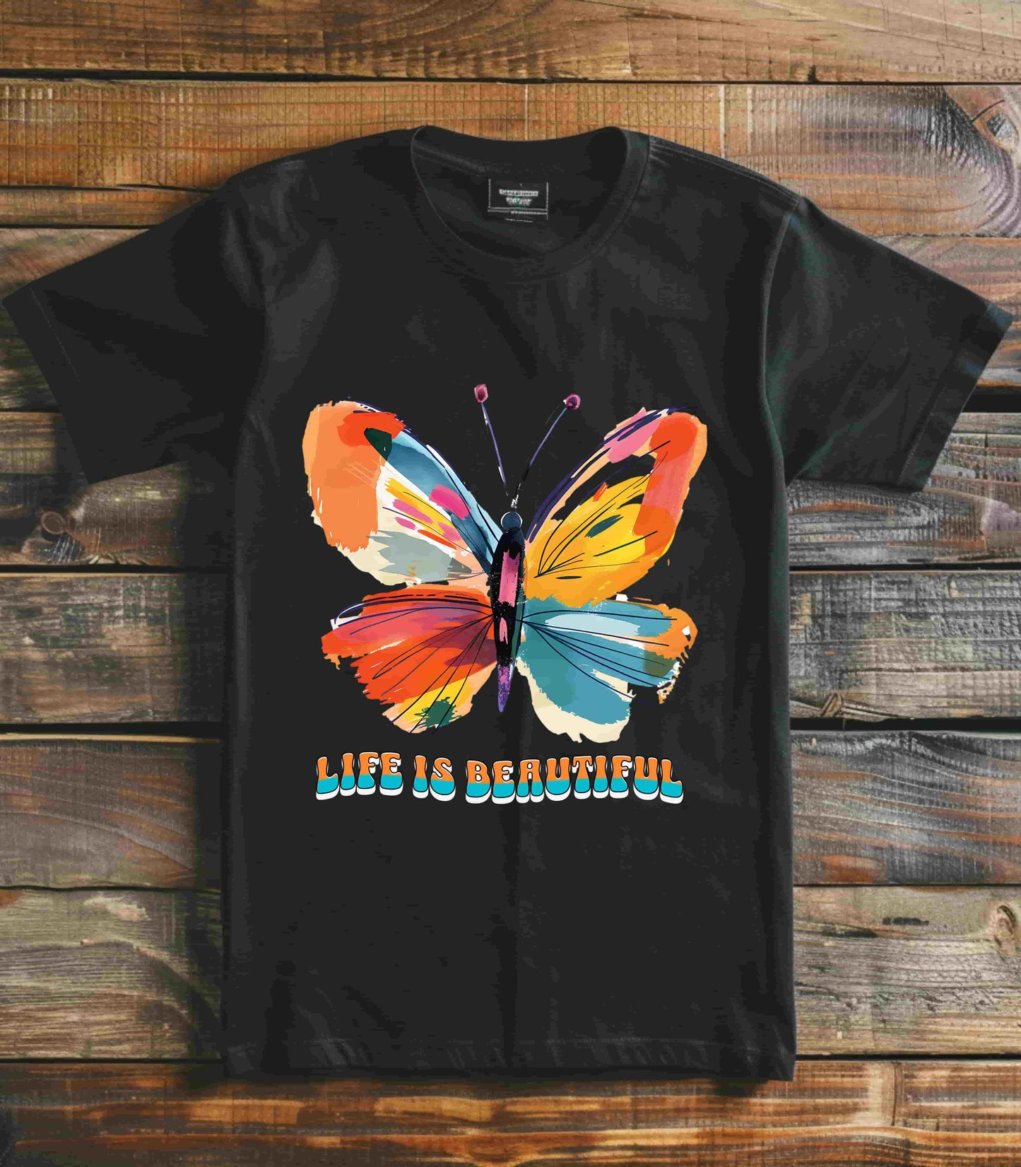 Colorful cartoon-style butterfly with vibrant wings and the text 'Life is Beautiful' designed for t-shirts in colors including Aqua, Athletic Heather, Berry, Black, Dark Grey Heather, Heather Red, Heather Team Purple, Heather True Royal, White, and Charity Pink